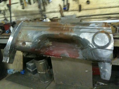 1993 Ford Bronco - A heavily rusted quarter panel, likely from a classic vehicle, sits in a workshop environment.