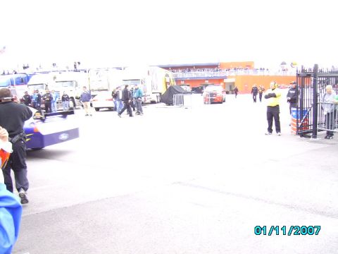 1978 Ford Bronco - Multiple vehicles and people gathered at a race track event.