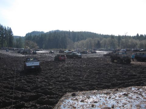 1996 Ford Bronco - Off-road vehicles navigate a challenging mud pit during an event.