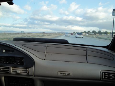 1995 Ford Taurus - Interior view of a 1995 Ford Taurus SHO on the highway, with other vehicles visible ahead.
