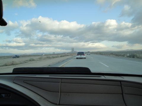 1995 Ford Taurus - Driving on a highway with several cars visible ahead under a dramatic sky.
