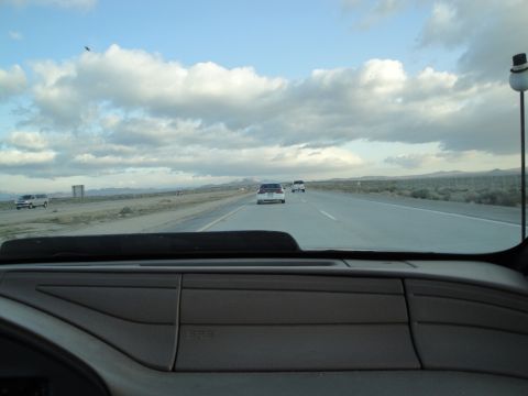 1995 Ford Taurus - Driving on a highway with a cloudy sky and distant mountains.