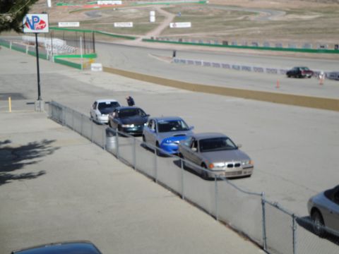1995 Ford Taurus - Several cars are lined up on a racetrack, with a silver sedan in the foreground.