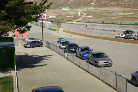 1995 Ford Taurus - Multiple cars are lined up on a race track, with mountains in the background and Toyota signage.
