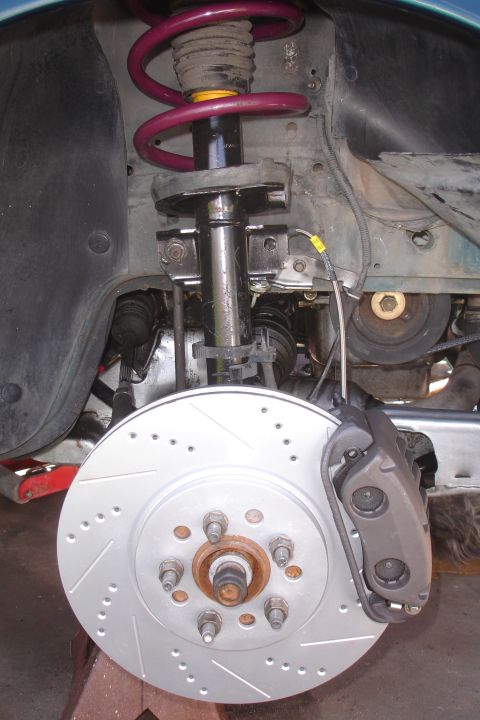 1995 Ford Taurus - Front brake assembly with drilled rotor and caliper, part of suspension system.