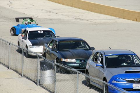 1995 Ford Taurus - Several cars are lined up on a race track, waiting for their turn.