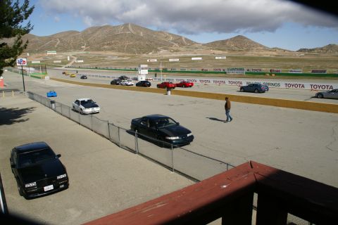 1995 Ford Taurus - Cars on a race track at Willow Springs, with mountains visible in the background.