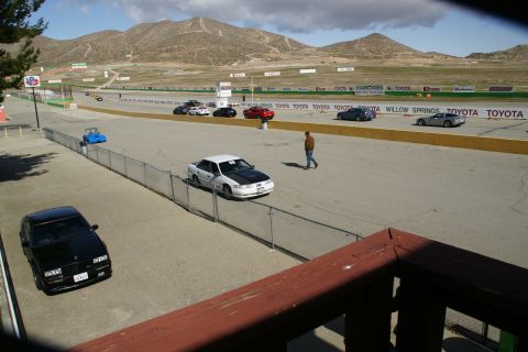 1995 Ford Taurus - A race track scene with multiple vehicles and a person walking.