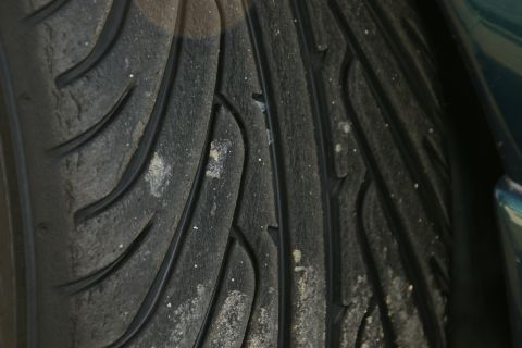 1995 Ford Taurus - Close-up view of a tire's tread pattern, showing wear and collected road debris.