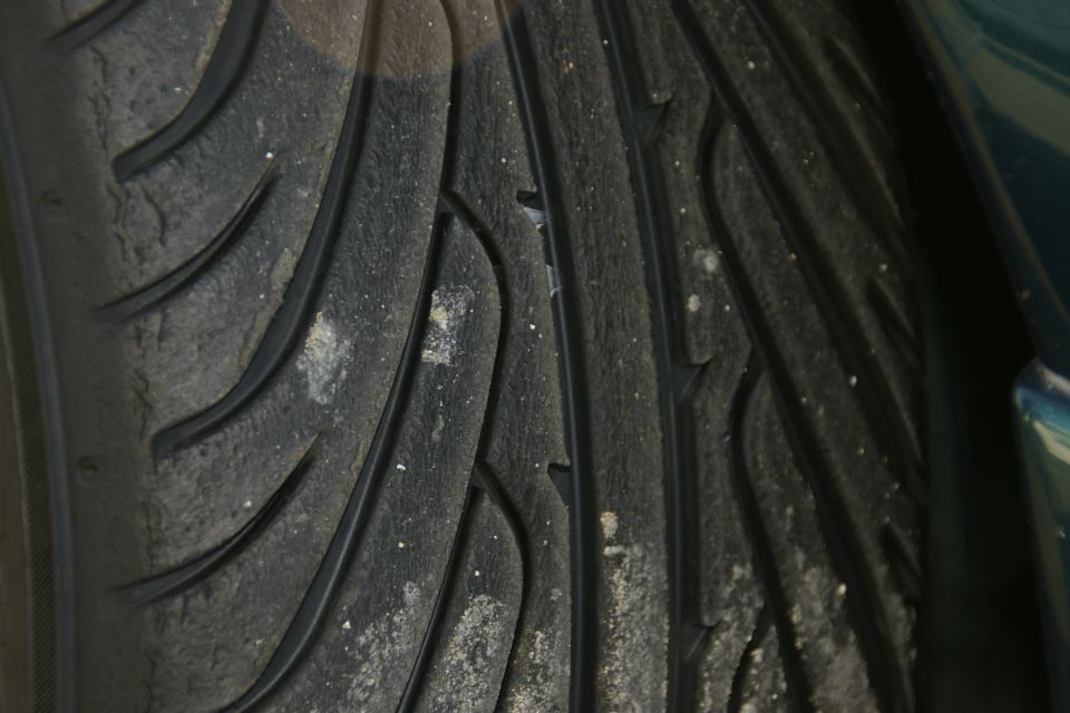Close-up of a worn tire tread with dirt and debris