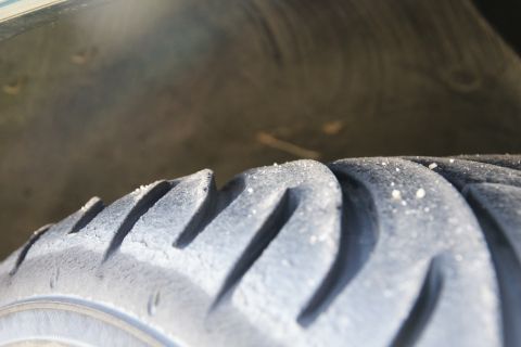 1995 Ford Taurus - A close-up view of a tire's tread pattern, showing wear and some debris.