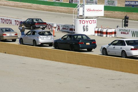 1995 Ford Taurus - Cars lined up on a race track with various sponsor signs visible.