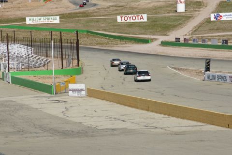 1995 Ford Taurus - Multiple cars are racing on the Willow Springs track, with various sponsor signs visible.