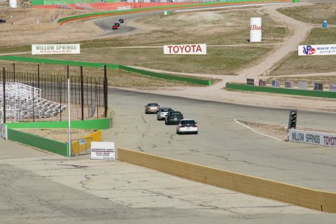 1995 Ford Taurus - Multiple cars race on a track at Willow Springs, with various sponsor signs visible.