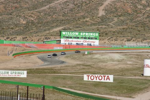 1995 Ford Taurus - Cars race on the track at Willow Springs, with the Budweiser Balcony building in the background.