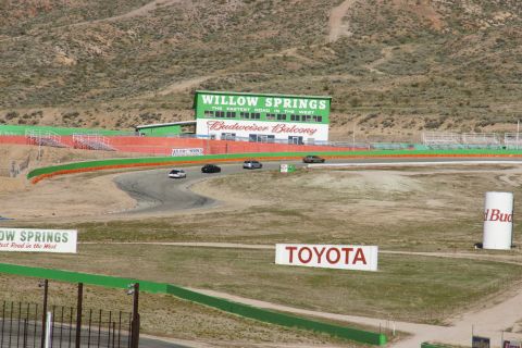 1995 Ford Taurus - Several cars race on a track at Willow Springs International Raceway, with prominent "Willow Springs" and "Toyota" signs visible.