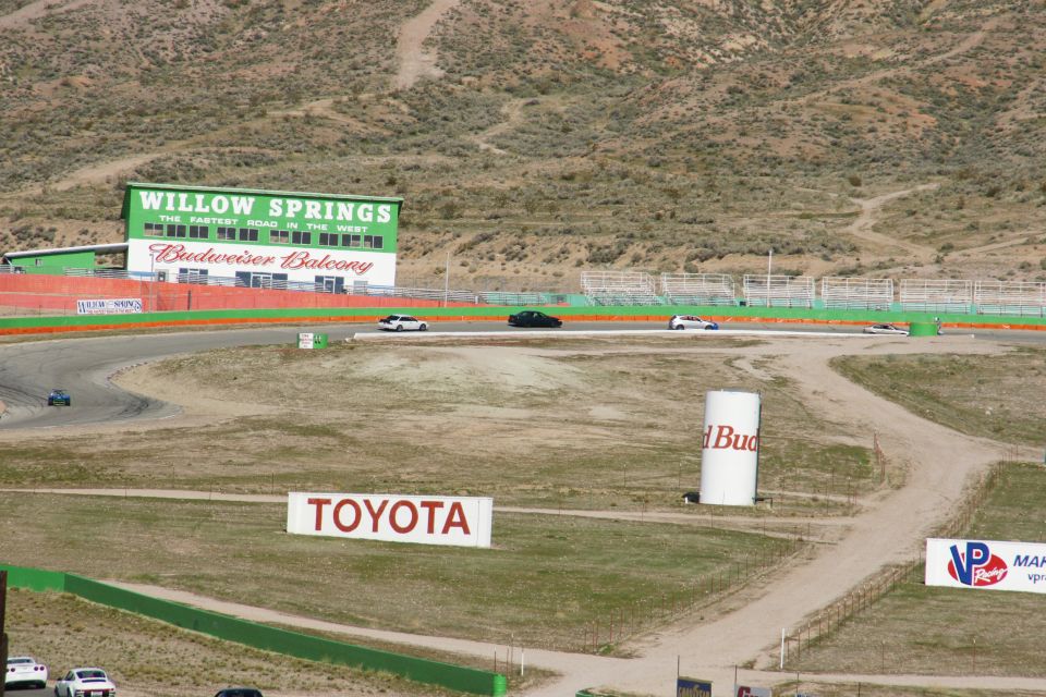 Willow Springs Raceway scene with Budweiser Balcony building and Toyota sign. Several cars are on the track