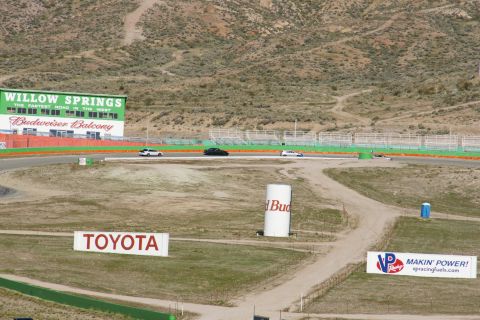 1995 Ford Taurus - Cars are seen on the Willow Springs International Raceway, with various sponsor signs in the background.