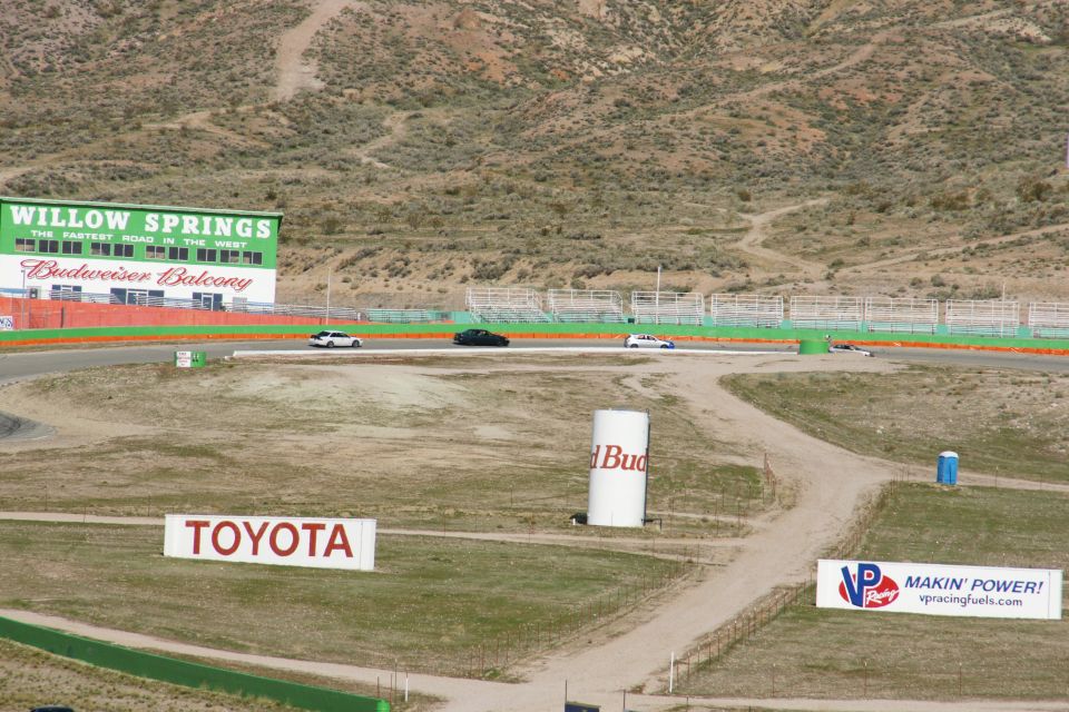 Cars on a race track with Willow Springs and Toyota signs visible