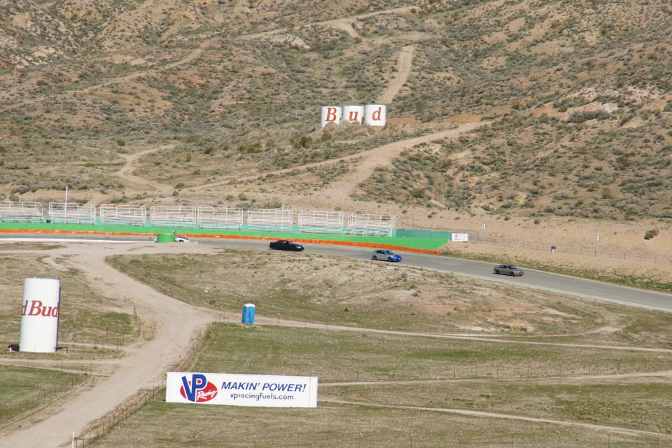 Race track with three cars, Budweiser water tower, and VP Racing Fuels banner