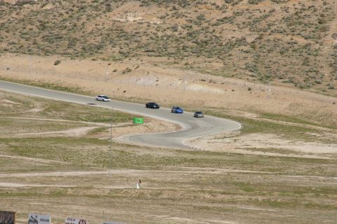 1995 Ford Taurus - Several cars navigate a serpentine road course surrounded by arid, undeveloped hillsides.