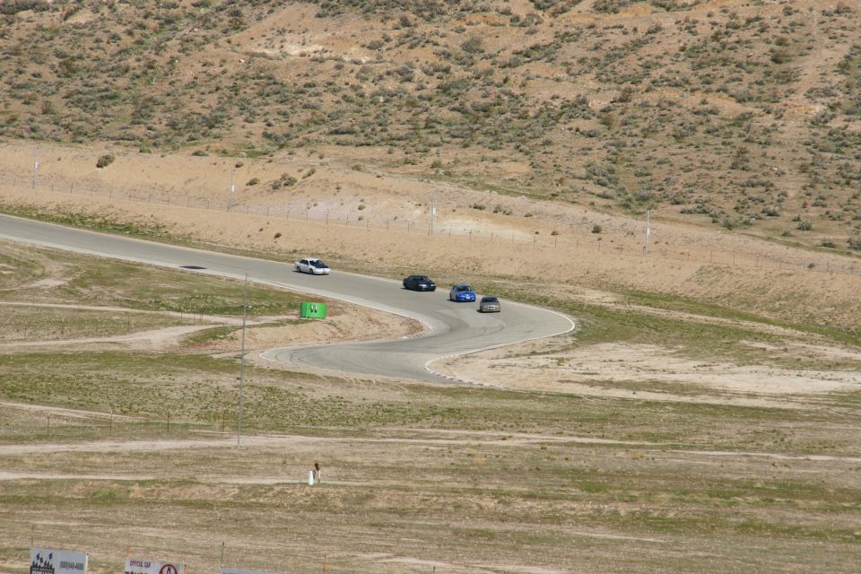 Cars driving on a winding road in a dry, hilly area