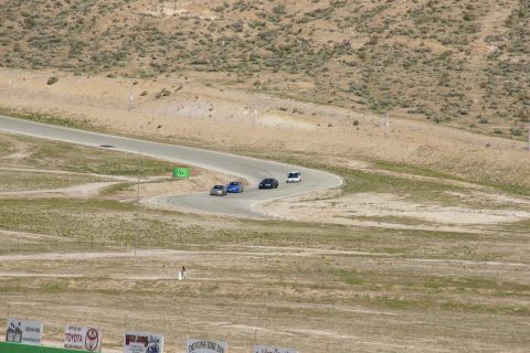 1995 Ford Taurus - Cars compete on a race track surrounded by arid hills and sparse vegetation.
