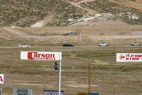 1995 Ford Taurus - Multiple vehicles are visible on a racetrack with advertising banners in the foreground.