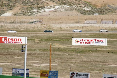 1995 Ford Taurus - Multiple vehicles compete on a racetrack, with various sponsor advertisements visible in the foreground.
