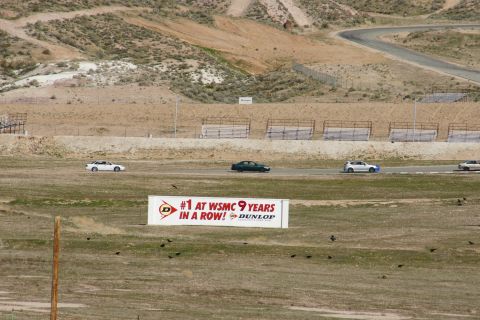 1995 Ford Taurus - Multiple vehicles race on a track with a Dunlop billboard visible in the foreground.