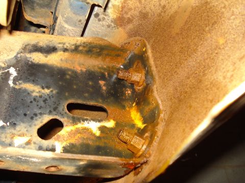 1985 Ford F-150 - Close-up of a heavily rusted metal bracket, likely from a vehicle's undercarriage.