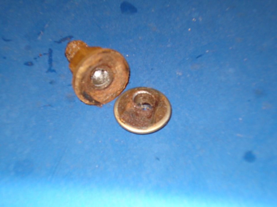 two rusty metal fasteners on a blue surface
