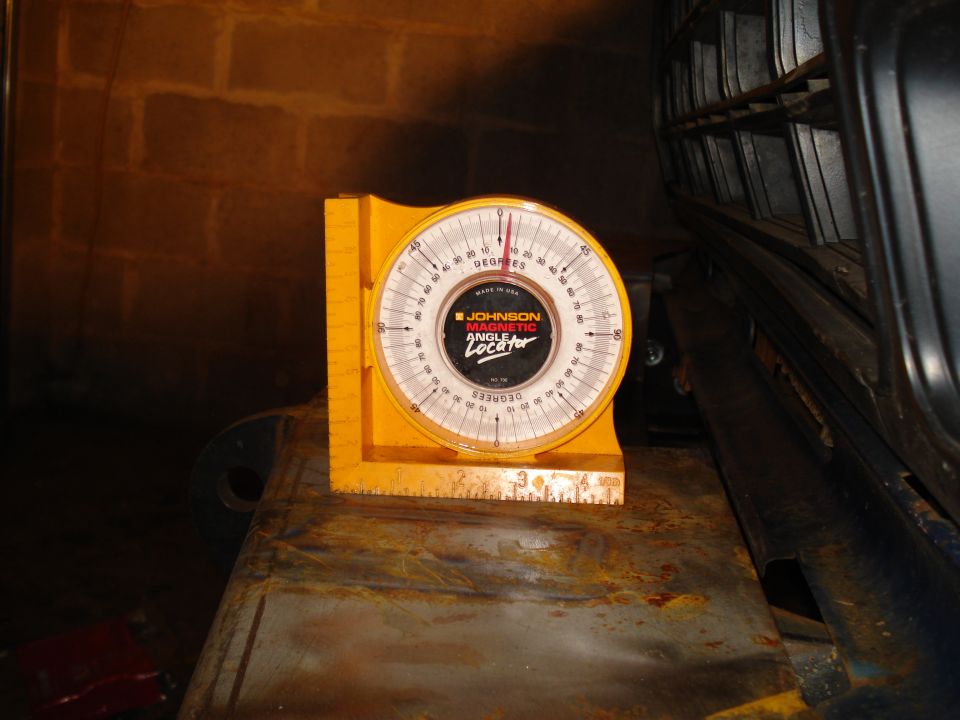 Yellow Johnson Magnetic Angle Locator tool with degrees marked, resting on a rusty metal surface