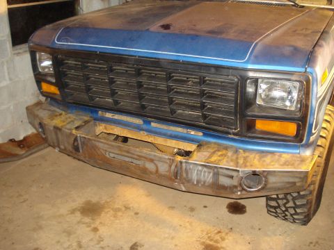 1985 Ford F-150 - Front view of a blue pickup truck with a custom bumper and black grille, likely from the early 1980s.