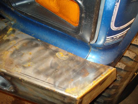 1985 Ford F-150 - Close-up of a 1985 Ford F-150's front corner, showing a custom steel bumper.