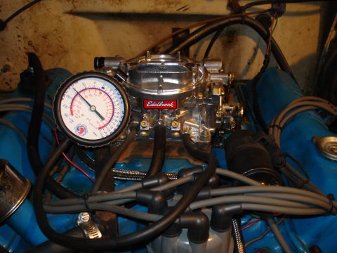1967 Ford F-250 - Engine bay detail showing a carburetor and a gauge connected to the engine.