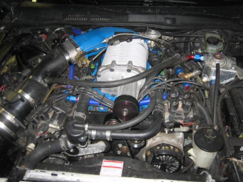 1996 Ford Thunderbird - The engine bay features a prominent supercharger and custom blue intake piping, suggesting performance modifications.
