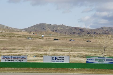 1995 Ford Taurus - Cars on a racetrack with advertising signs in the foreground.