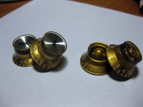 1989 Mazda MX-6 - Gold guitar control knobs labeled VOLUME and TONE are shown alongside two other similar knobs.