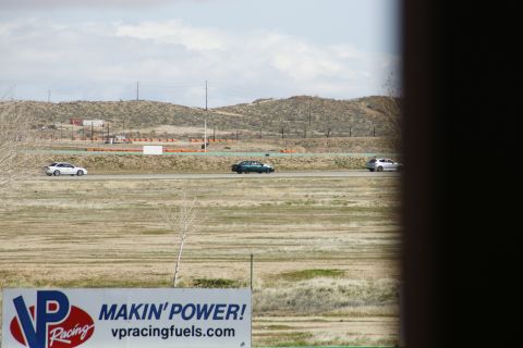 1995 Ford Taurus - Multiple vehicles race on a track with hills in the background and a VP Racing Fuels sign in the foreground.