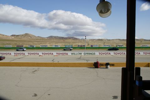 1995 Ford Taurus - Multiple vehicles are visible on a racetrack under a cloudy sky.