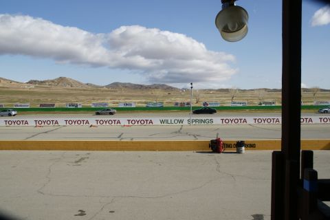 1995 Ford Taurus - A view of a racetrack with several cars visible, sponsored by Toyota and Willow Springs signage.