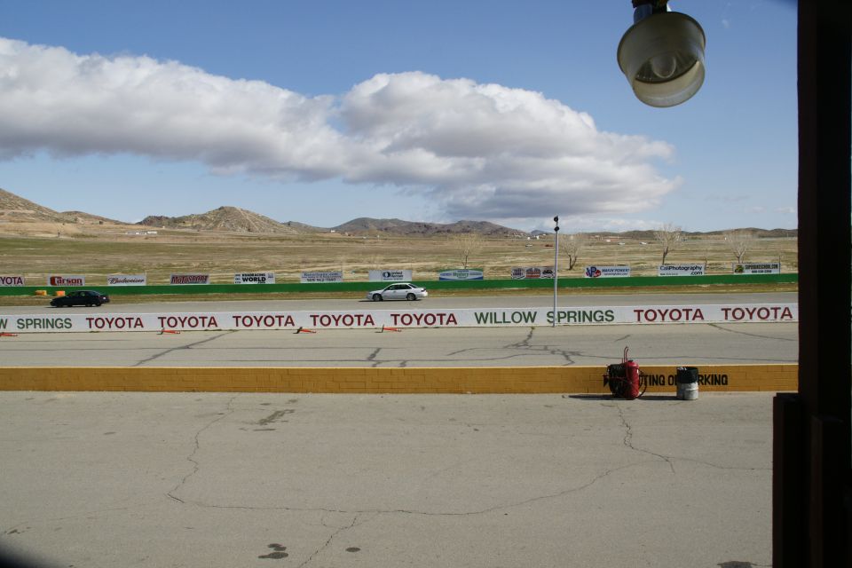 Race track with two cars driving, Toyota sponsorship banners visible