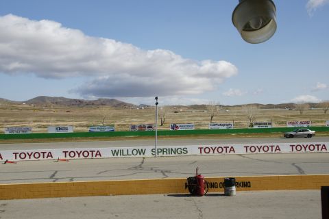1995 Ford Taurus - A silver sedan drives on a race track with various sponsor banners visible in the background.