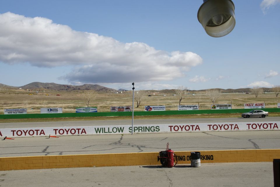 Silver sedan on a race track, side view, with Toyota and Willow Springs banners