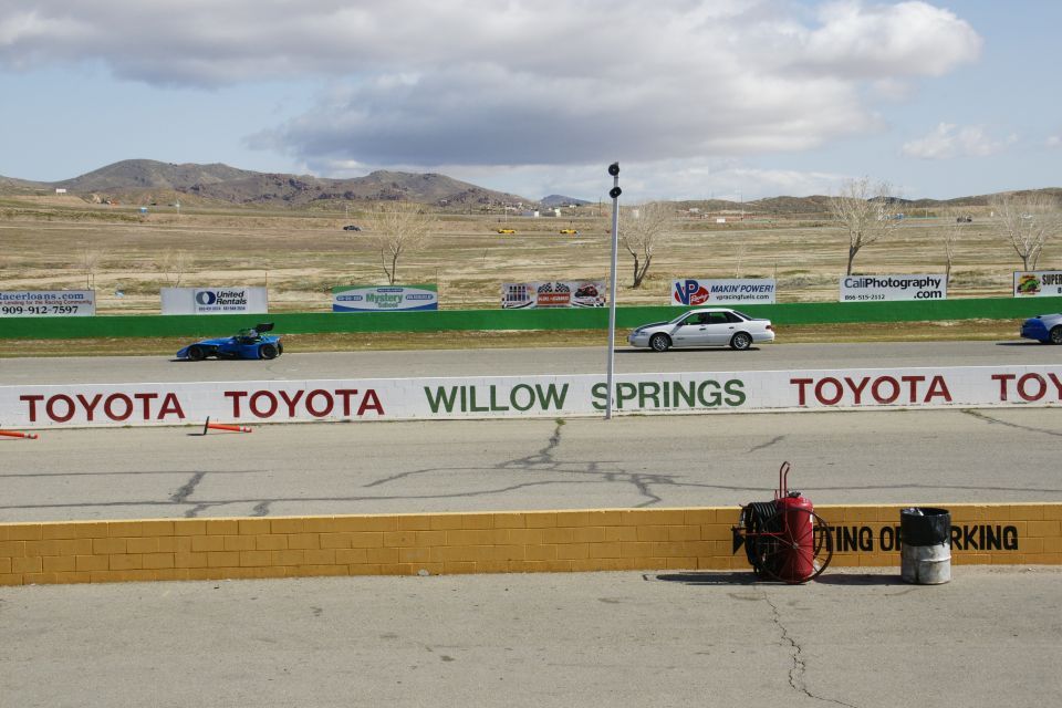 Silver sedan on race track with Toyota Willow Springs signage