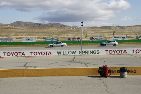 1995 Ford Taurus - Cars race on a track at Willow Springs, with sponsor banners visible.