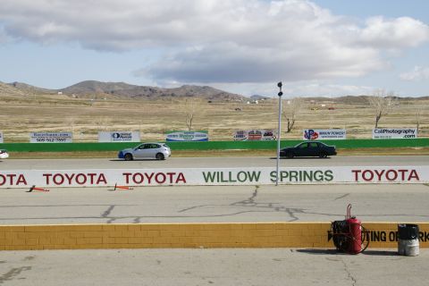 1995 Ford Taurus - Two cars are seen on a racetrack with various sponsor banners in the background.