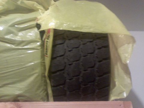 1996 Ford Bronco - A tire is covered in yellow protective wrap, showing its tread pattern.