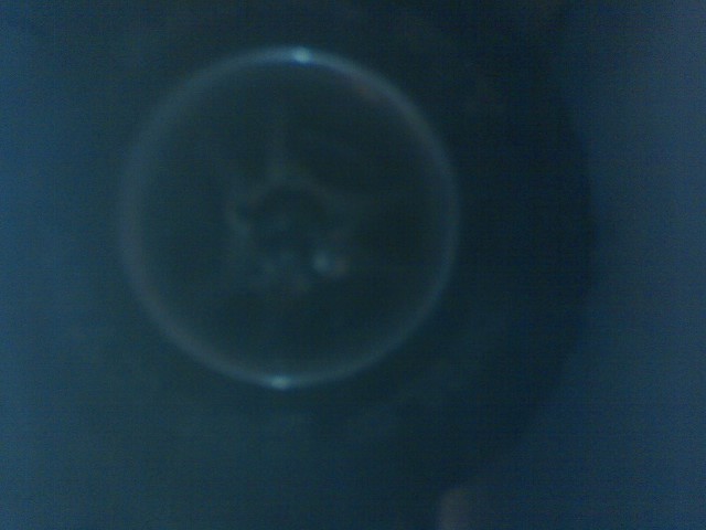 Close-up of a vehicle headlight lens with a faint glow